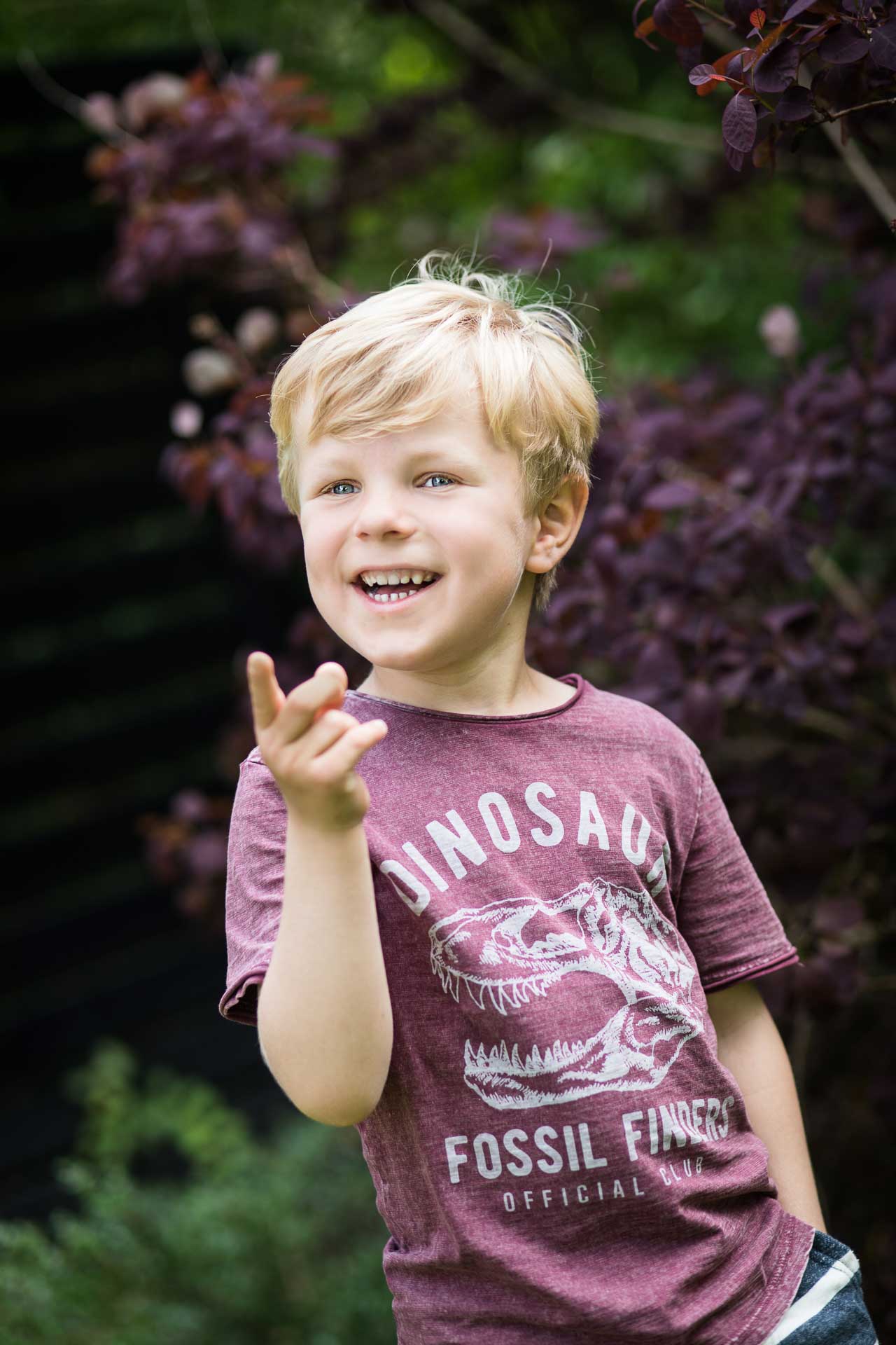 En glad og legesyg dreng, der hopper i en stor vandpyt i en park i Odense, fanget af en dygtig børnefotograf.